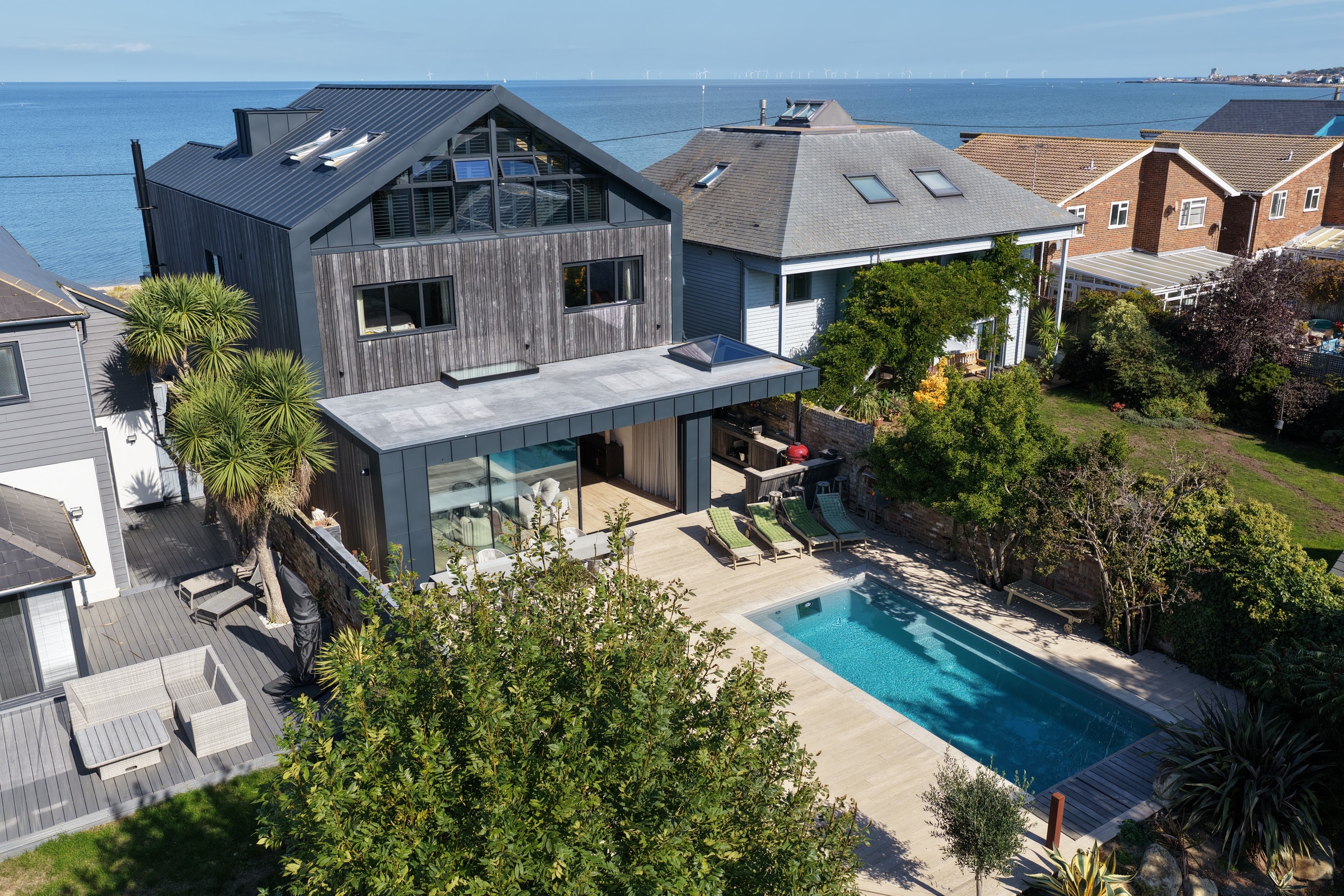 Aerial view of a modern house with a swimming pool beside the sea