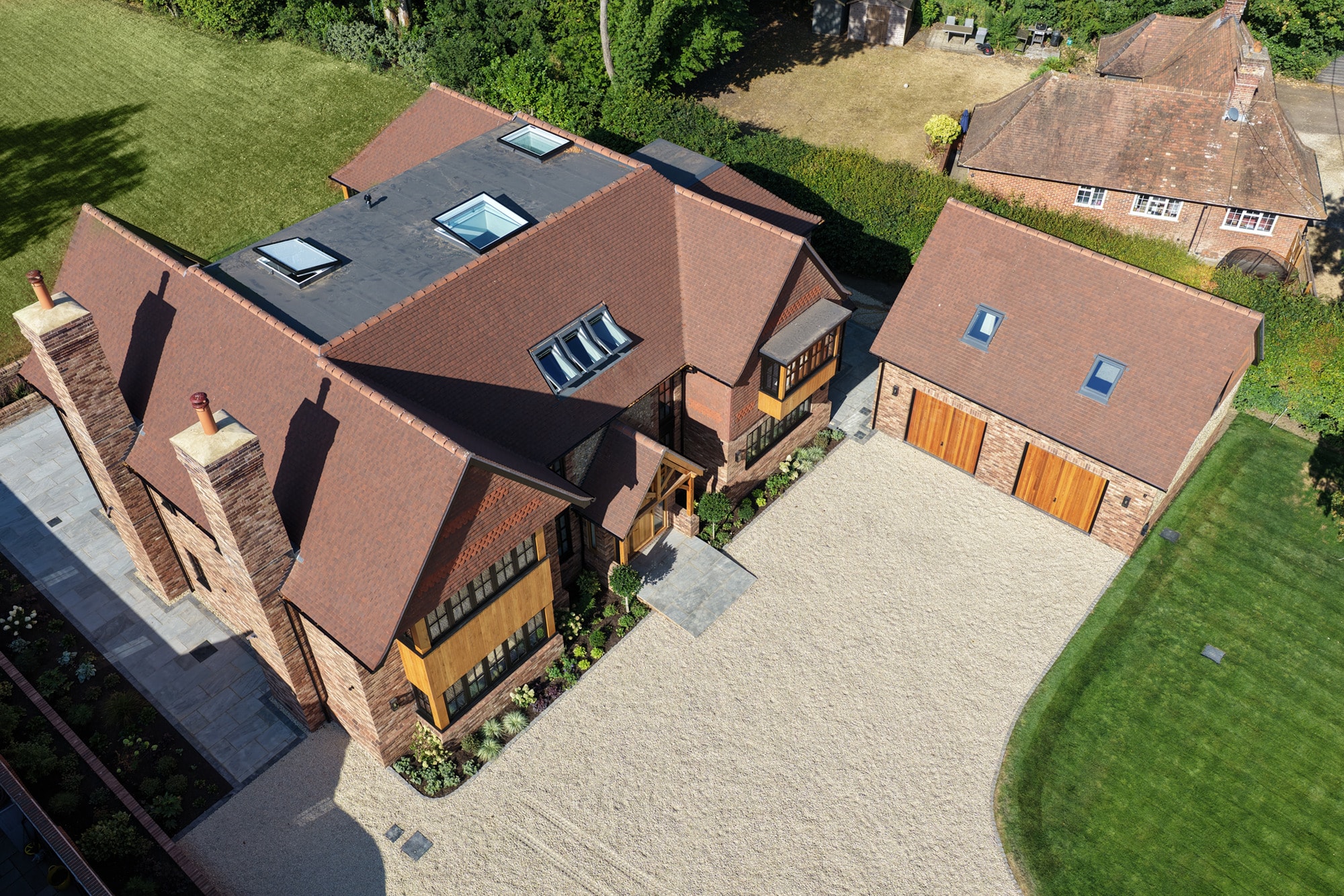 Aerial view of a brick house roof, chimneys and garage